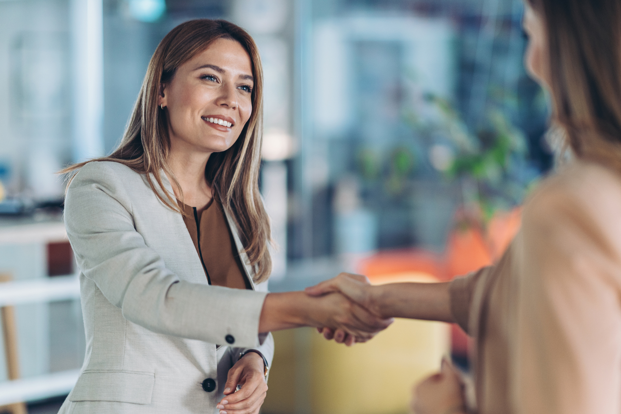 Smiling businesswoman welcoming a guest in the office